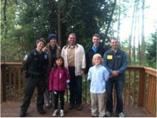 WA State Rep. Strom Peterson and Ranger Bohan stand with students and parents on the MEco Outdoor Classroom stage.